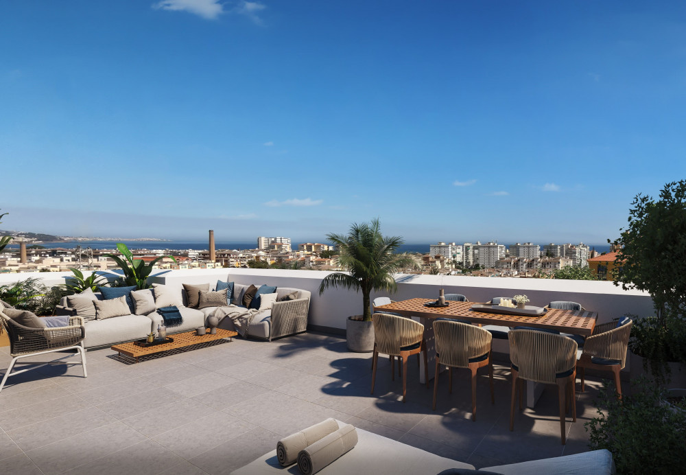Spacious terrace with modern seating and dining area, offering panoramic views of Torre del Mar, Málaga and the coastline.